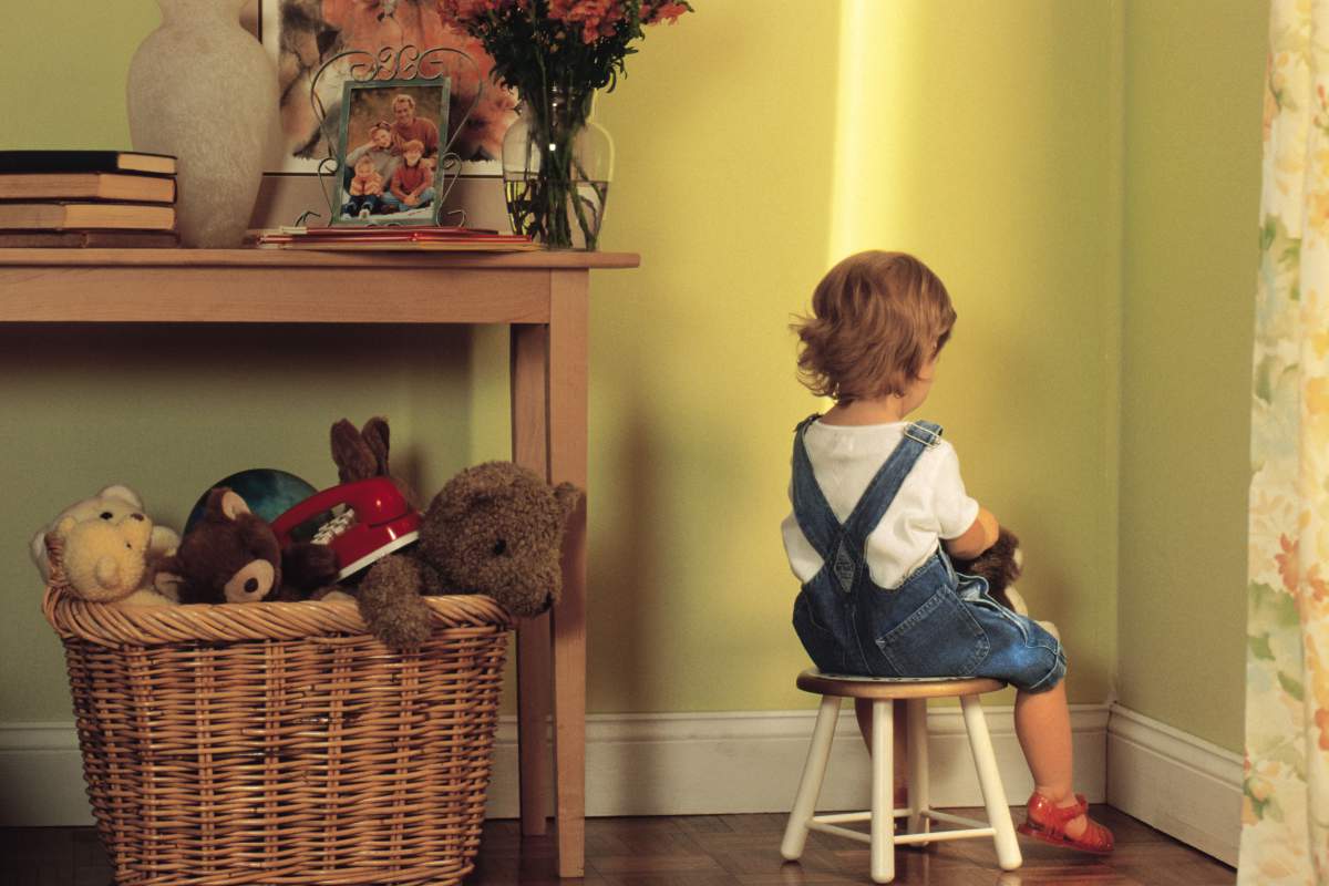 Young child sitting in corner as punishment